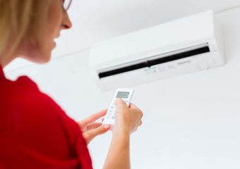 A photo of a woman operating the air conditioning.